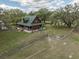Aerial view of fenced home with a wraparound porch and a large grassy lot at 8091 C 476B, Bushnell, FL 33513