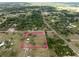 Aerial view of a home inside the property lines, surrounded by lush greenery and mature trees at 8091 C 476B, Bushnell, FL 33513