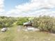 Wide aerial view of the house, outbuildings, and surrounding mature trees, offering a serene rural setting at 8091 C 476B, Bushnell, FL 33513
