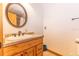 Bright bathroom showcasing a wood vanity, cream countertop, and an oval mirror with a neutral color palette at 8091 C 476B, Bushnell, FL 33513