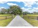Long driveway leading to a home surrounded by mature trees and lush greenery on a sunny day at 8091 C 476B, Bushnell, FL 33513