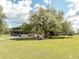 Beautifully landscaped home with a large covered porch and a decorative rock garden feature at 8091 C 476B, Bushnell, FL 33513