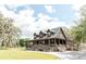 Charming home with a large porch, wooden details, and mature trees and lush landscaping at 8091 C 476B, Bushnell, FL 33513