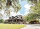 Charming home with wraparound porch, ramp, and covered parking area, surrounded by trees at 8091 C 476B, Bushnell, FL 33513