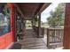Charming front porch with wood floors, bench, and scenic views of the expansive front yard at 8091 C 476B, Bushnell, FL 33513