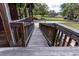 Front porch ramp leading to the yard, framed by wooden railings and lush greenery at 8091 C 476B, Bushnell, FL 33513