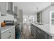 Stylish kitchen with stainless steel appliances, grey cabinets, and a view of the dining and living areas at 811 N Swindell #2 Ave, Lakeland, FL 33810