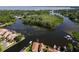 Aerial view of a waterfront community featuring lush greenery, canals, and lake views at 830 Palm Harbor Ct, Leesburg, FL 34748