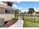 Beautiful backyard with a black fence, lush greenery, and waterway access with a firepit at 830 Palm Harbor Ct, Leesburg, FL 34748