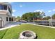 Expansive backyard with a firepit, lush green grass, and waterway access with boat docks at 830 Palm Harbor Ct, Leesburg, FL 34748