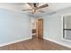 Bedroom with wood floors, blue walls, ceiling fan, and closet at 830 Palm Harbor Ct, Leesburg, FL 34748