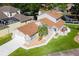 Charming waterfront home featuring a manicured lawn, landscaping, and attached garage at 830 Palm Harbor Ct, Leesburg, FL 34748