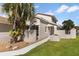 Stucco home showcasing a well-manicured lawn and a mature palm tree for added curb appeal at 830 Palm Harbor Ct, Leesburg, FL 34748