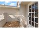 Front door is white with glass panes and opens to a patio with decorative rocks at 830 Palm Harbor Ct, Leesburg, FL 34748