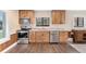Well-lit kitchen showcases natural wood cabinets, stainless steel appliances, and durable wood flooring at 830 Palm Harbor Ct, Leesburg, FL 34748
