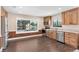 Spacious kitchen with modern appliances and wood cabinets, complemented by scenic lake view through a wide window at 830 Palm Harbor Ct, Leesburg, FL 34748