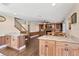 Open-concept living area featuring wood cabinets, island counters, wood flooring, staircase, and fireplace at 830 Palm Harbor Ct, Leesburg, FL 34748