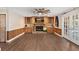 Spacious living room with built-in wood cabinets, brick fireplace, wood flooring, and patio doors at 830 Palm Harbor Ct, Leesburg, FL 34748