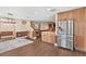 Open living space with wood cabinets, island counters, wood floors, staircase, and stainless fridge at 830 Palm Harbor Ct, Leesburg, FL 34748