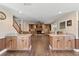 Open-concept living area with wood cabinets, island counters, wood flooring, and a cozy brick fireplace at 830 Palm Harbor Ct, Leesburg, FL 34748
