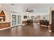 Open concept living area with wood-look floors leading to the modern kitchen and bright breakfast nook at 830 Palm Harbor Ct, Leesburg, FL 34748