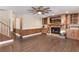 Warm living room with brick fireplace, wood flooring, built-in wood cabinets, and a ceiling fan at 830 Palm Harbor Ct, Leesburg, FL 34748