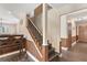 Hallway with stairs to upper floor featuring wood paneling and trim, with access to kitchen at 830 Palm Harbor Ct, Leesburg, FL 34748