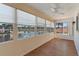 Sunroom featuring many windows with view of lake, wood floor and ceiling fan at 830 Palm Harbor Ct, Leesburg, FL 34748