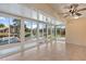Bright sunroom with floor-to-ceiling windows offering panoramic views of the waterfront and dock at 830 Palm Harbor Ct, Leesburg, FL 34748