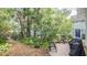 Beautiful backyard with mature trees, a grill, and a brick patio, perfect for outdoor entertaining and relaxation at 908 N Tremain St, Mount Dora, FL 32757