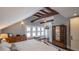 Spacious bedroom featuring wooden beams, hardwood floors, and natural light from multiple windows at 908 N Tremain St, Mount Dora, FL 32757