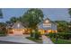 Charming home featuring a detached garage, a paved driveway, and a beautifully landscaped front yard at 908 N Tremain St, Mount Dora, FL 32757