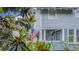 Charming home exterior showcasing a cozy covered porch with an American flag, framed by lush greenery at 908 N Tremain St, Mount Dora, FL 32757