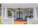 Charming front porch with a rocking chair and double doors, perfect for relaxing and enjoying the outdoors at 908 N Tremain St, Mount Dora, FL 32757