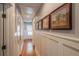 Bright hallway with hardwood floors, wainscoting, and decorative artwork at 908 N Tremain St, Mount Dora, FL 32757