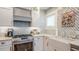 Updated kitchen showcasing marble counters, stainless steel appliances, and a farmhouse sink at 908 N Tremain St, Mount Dora, FL 32757
