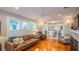 Bright living room boasts hardwood floors, a comfortable leather sofa, and an open layout to the kitchen at 908 N Tremain St, Mount Dora, FL 32757
