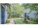Charming side yard featuring a brick pathway, a fountain, and a variety of lush plants and shrubbery at 908 N Tremain St, Mount Dora, FL 32757