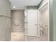 Modern bathroom with walk-in shower, glass block partition, and accessible toilet at 1016 Pickering Path, The Villages, FL 32163