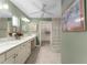 Ensuite bathroom features double sinks, a long vanity, and a glass block enclosed shower at 1016 Pickering Path, The Villages, FL 32163