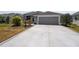 Close up of concrete driveway leading to a gray two car garage door at 1016 Pickering Path, The Villages, FL 32163