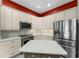 Bright kitchen features stainless steel appliances, a movable island, and custom white cabinetry at 1016 Pickering Path, The Villages, FL 32163