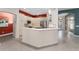 Bright kitchen featuring white cabinets, stone countertops, and modern stainless steel appliances at 1016 Pickering Path, The Villages, FL 32163