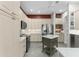 Bright kitchen features stainless steel appliances, a movable island, and custom white cabinetry at 1016 Pickering Path, The Villages, FL 32163