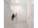 Functional laundry room with washer, dryer, and storage space at 1016 Pickering Path, The Villages, FL 32163