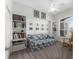 Bright living room showcasing built-in bookshelves, cozy sofa and a large window with a rocking chair at 1016 Pickering Path, The Villages, FL 32163
