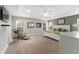 Spacious main bedroom features a tray ceiling, carpet, and natural light from the many windows at 1016 Pickering Path, The Villages, FL 32163