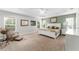 Spacious main bedroom features a tray ceiling, carpet, and natural light from the many windows at 1016 Pickering Path, The Villages, FL 32163