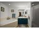 Bright bathroom features a tub, glass shower, blue vanity, and neutral color palette at 1017 Bluegrass Dr, Groveland, FL 34736