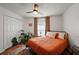 Warm bedroom with cozy bed, monstera plant, hardwood floors, and a ceiling fan at 1017 Bluegrass Dr, Groveland, FL 34736